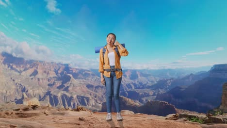full body of asian female hiker with mountaineering backpack smiling and showing call me gesture while traveling at the top of mountain