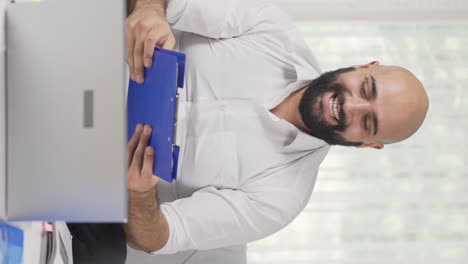 Vertical-video-of-Home-office-worker-man-looking-at-paperwork-files.