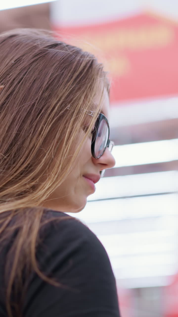 comprador con camiseta negra y gafas centrándose en algo por delante en un centro comercial bien iluminado mientras se mueve a través de la zona comercial, con señales borrosas y iluminación bokeh que crea un efecto de fondo vibrante