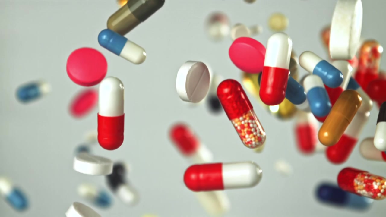 Colorful Pills and Capsules Falling in Slow Motion