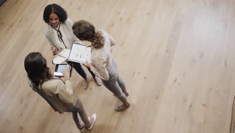 Diversas-Colegas-Femeninas-En-Discusión-Usando-Tableta-En-El-Salón-De-La-Oficina,-Cámara-Lenta