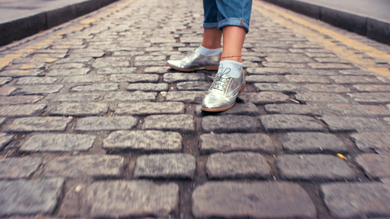 mujer caminando por la calle de adoquines