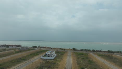 Aerial-view-of-Arabian-Ocean-seashore-in-Karachi,-Pakistan,-with-heavy-clouds-in-the-sky-in-the-background