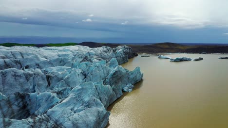 aerial view of svinafellsjokull glacier with crack blue ice and veins of black ash in iceland