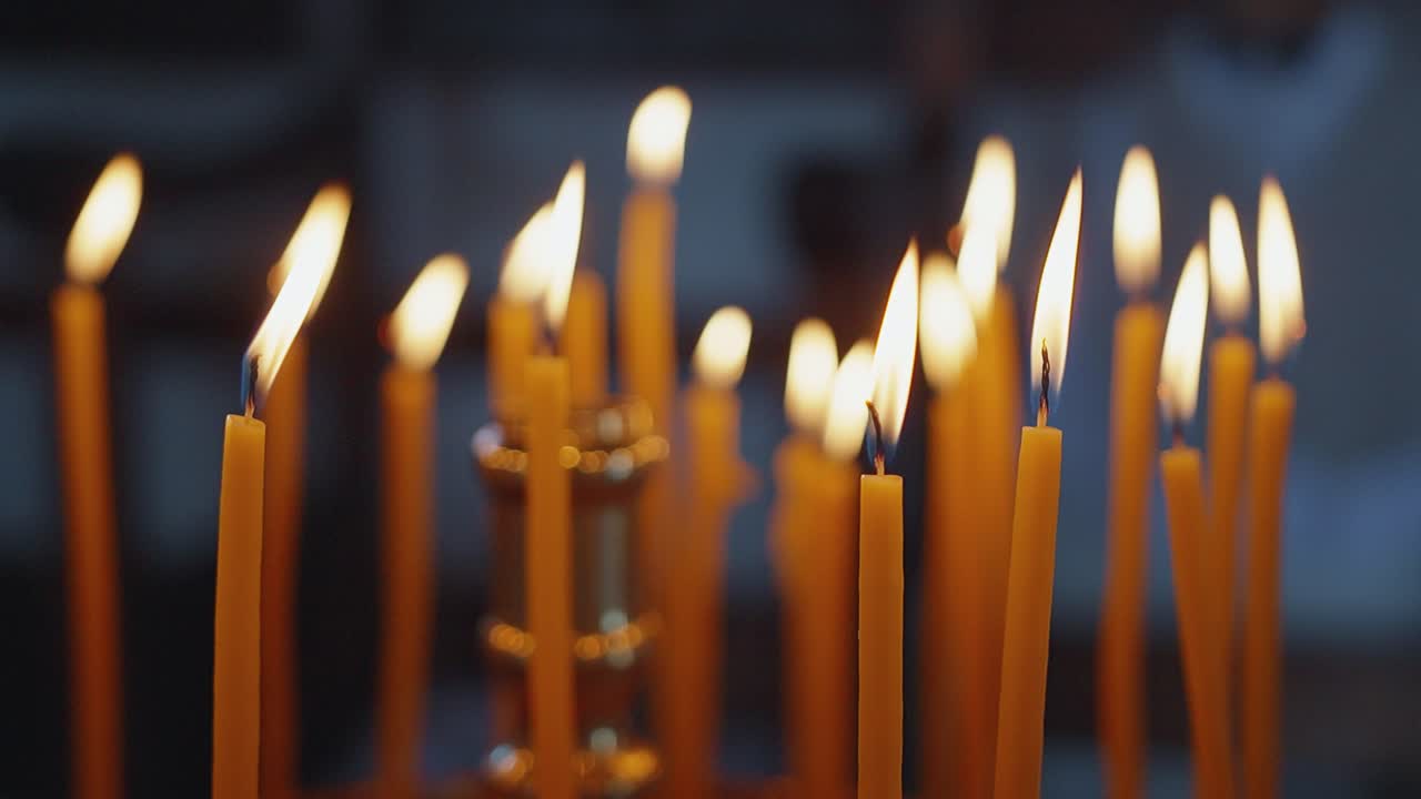 Candele accese su un supporto creano un'atmosfera serena e contemplativa.