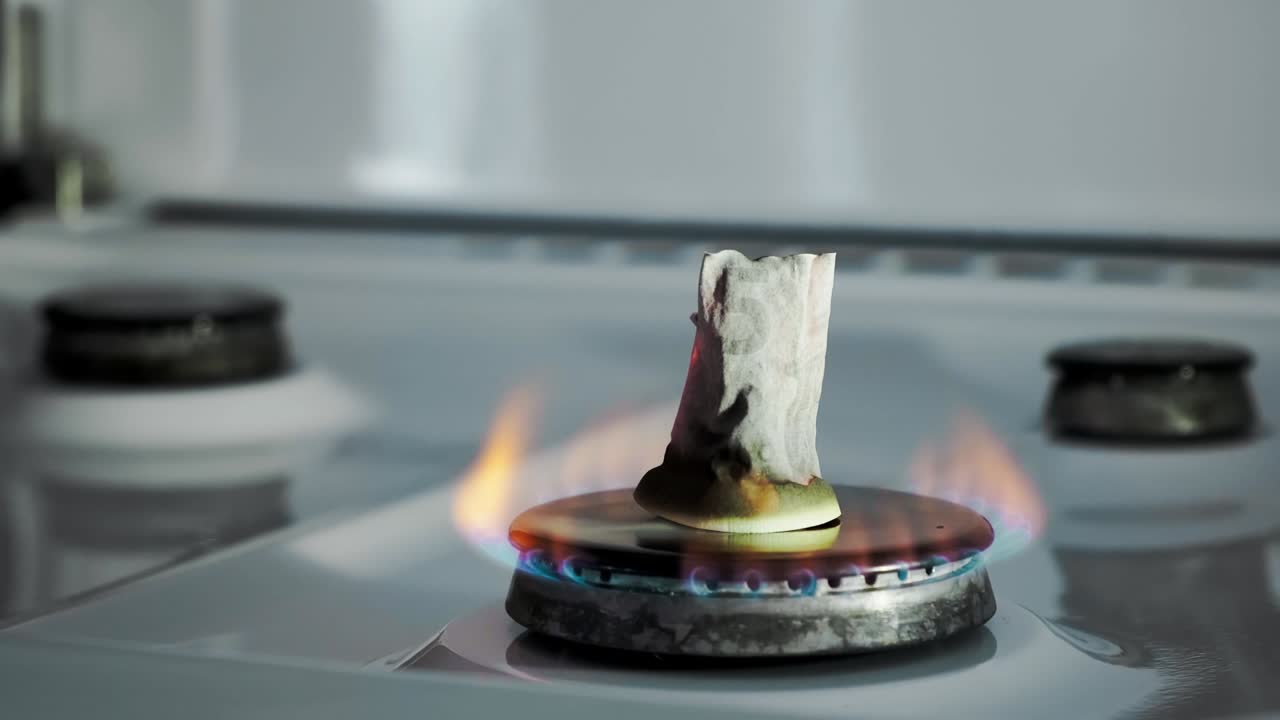 가스 위기의 개념 5 유로 지폐는 주방 스토브 버너에서 불타고 있습니다 유럽 현금 - 천연 자원의 높은 가격 - 화재 불꽃 - 유리티 부채 - 에너지 전쟁 - 가정 예산을 절약합니다.