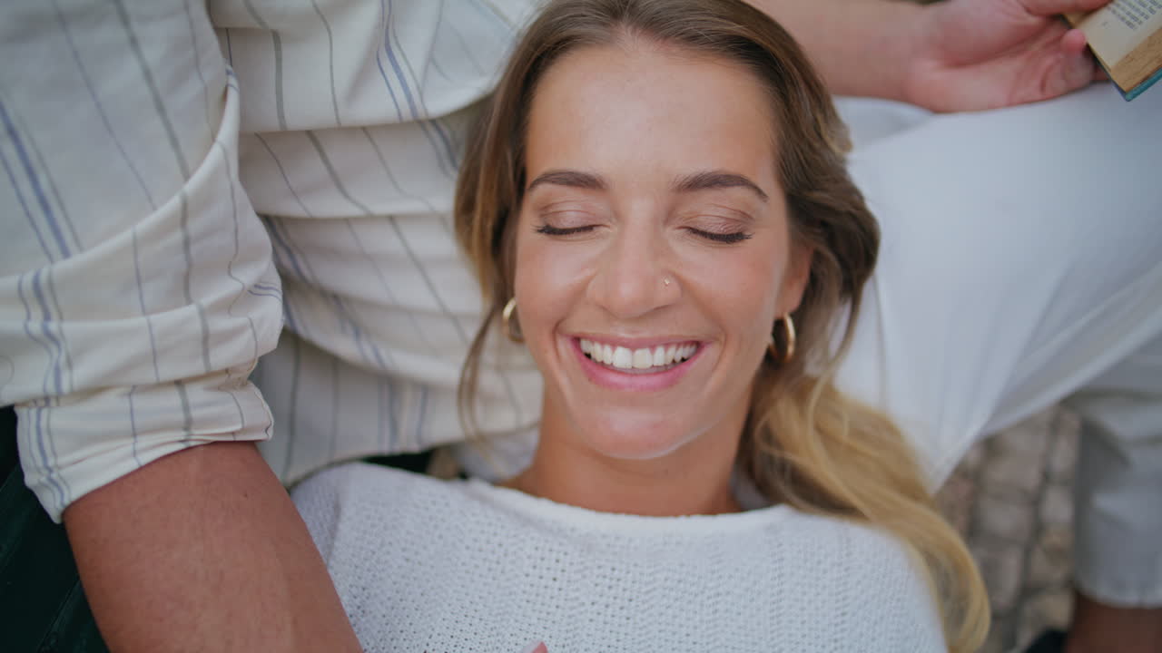 closeup mujer riendo descansando novio rodillas en el banco. mujer tocando el hombre mano