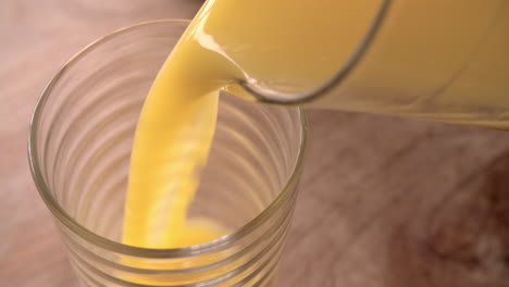 slow motion shot of pouring orange juice into glass