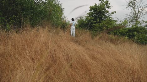 A-young-teenager-in-a-dry-straw-checking-the-surroundings-for-the-environmental-conservation-concept