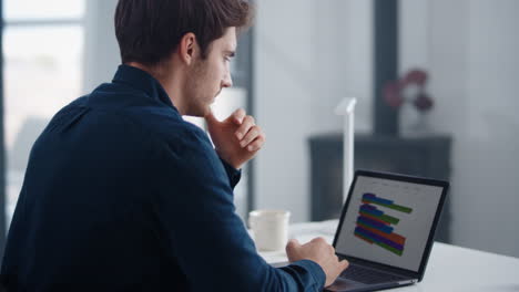 Porträt-Männlicher,-Professionell-Aussehender-Diagramme-Auf-Einem-Notebook-Im-Heimbüro