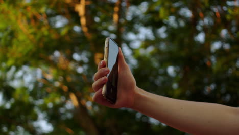 hand-holding-modern-smartphone-while-travelling-outdoor-filming-recording-selfie-to-share-on-social-media-of-holiday-trip-travel-destination-content-creator