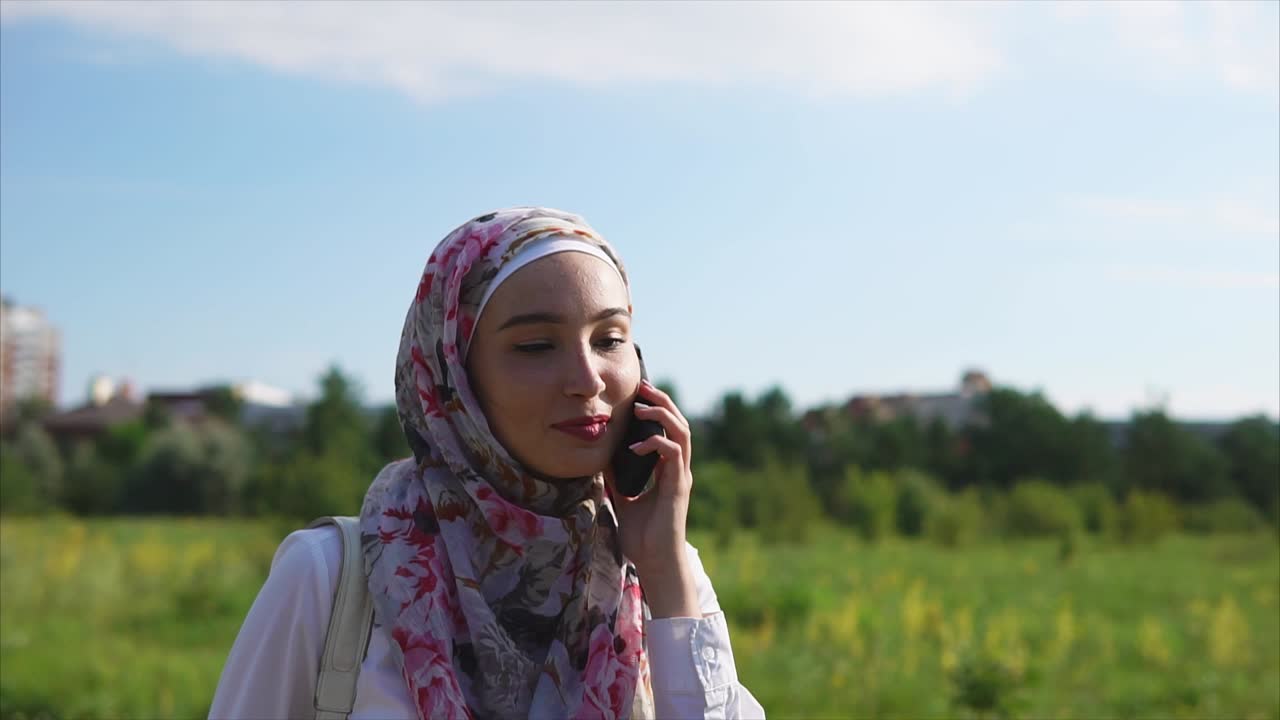 Young Woman Talking on Phone in Park