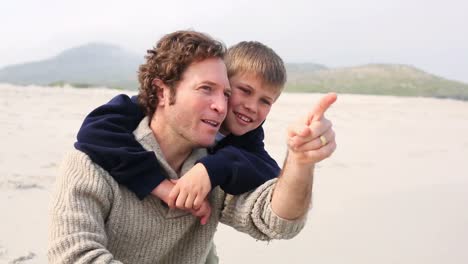 El-Hombre-Lleva-A-Cuestas-A-Su-Hijo-En-La-Playa.