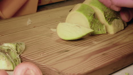 food prep: raw turnip vegetable is sliced into pieces, close up view