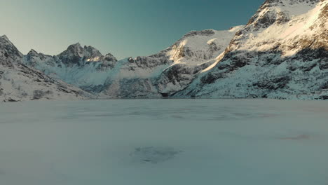 Drone-shot-of-a-frozen-lake-in-lofoten-with-mountains-in-the-background