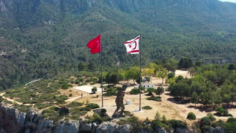 a drone flight on the top a mountain towards the flags of turkey and the turkish republic of cyprus