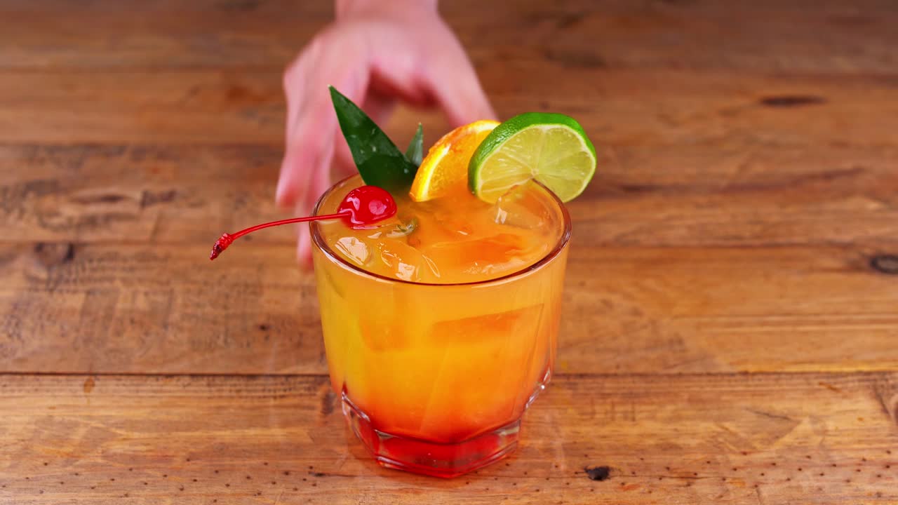 cerca de un cóctel de mezcal siendo retirado de una mesa de madera en un restaurante