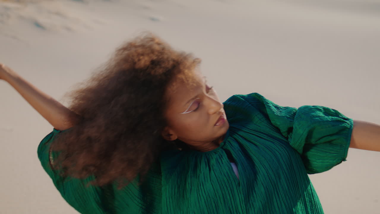 Woman artist performing desert sand close up. African girl dancing sensually.