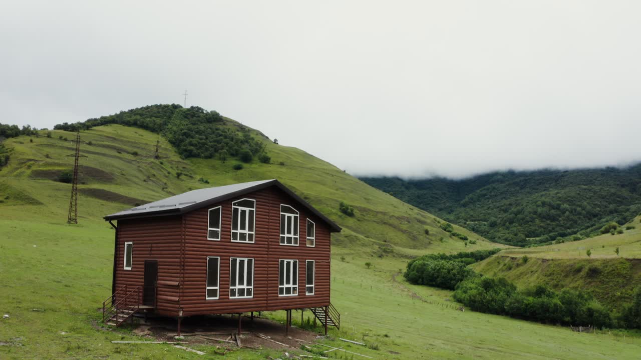 casa de madera rústica enclavada en un valle de montaña verde