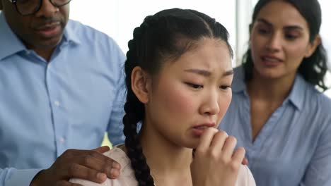 a tense interaction unfolds in a contemporary office space, highlighting a woman visibly distressed in response to a man's challenging demeanor. the atmosphere is charged with emotion.