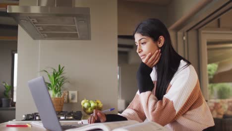 Video-De-Una-Mujer-Birracial-Enfocada-Aprendiendo-Con-Una-Computadora-Portátil-En-Casa