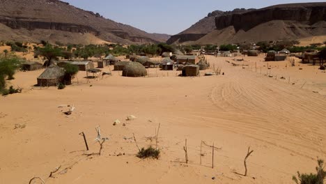 rural thatch huts in terjit oasis in poverty-stricken village, mauritania - aerial drone view