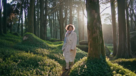 brunette enjoy tranquil stroll on sunlit forest trail at morning. woman walking