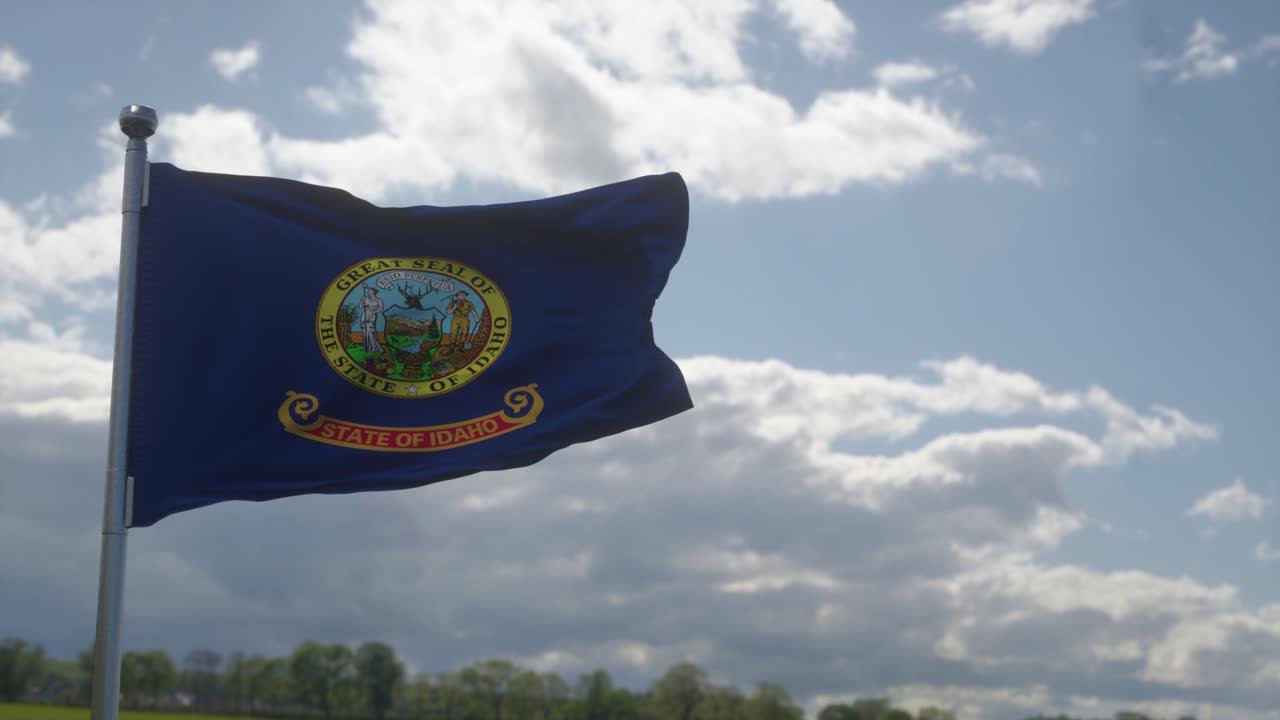 Bandera de Idaho en un mástil ondeando al viento en el cielo. Estado de Idaho en los Estados Unidos de América