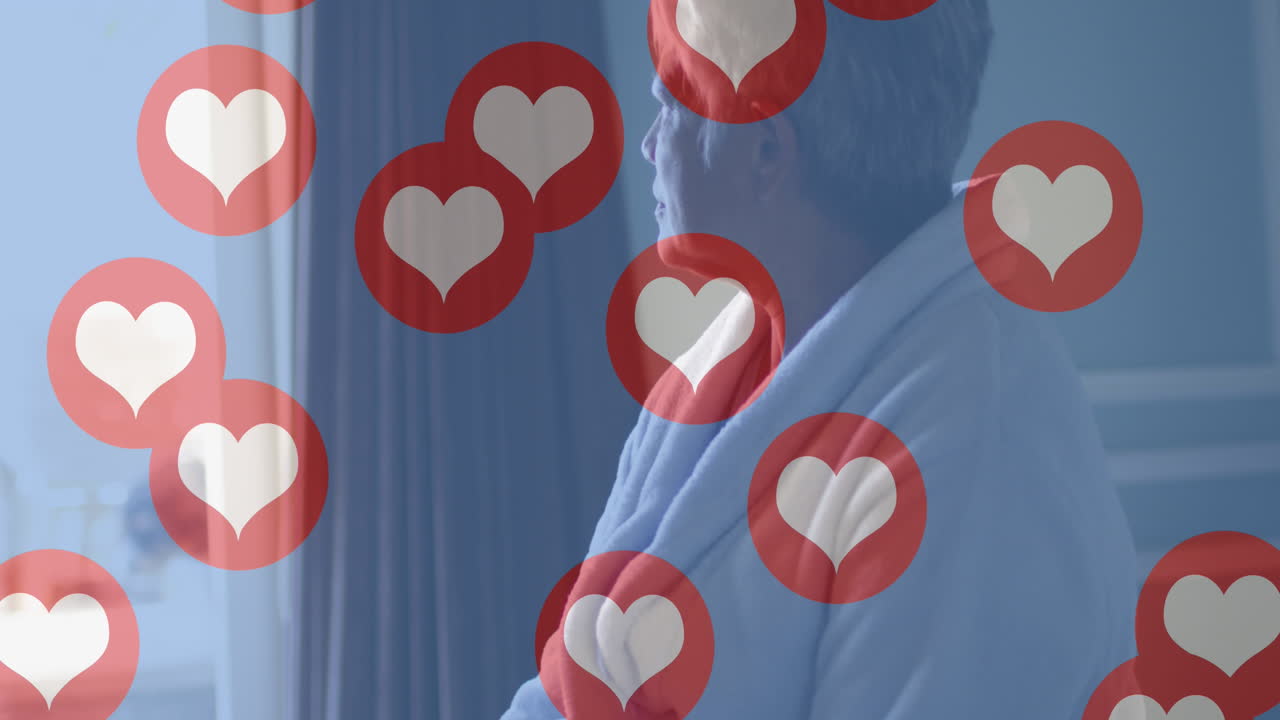 배경에 침대에 앉아 있는 고령 여성 위에 심장 사랑 아이콘의 애니메이션