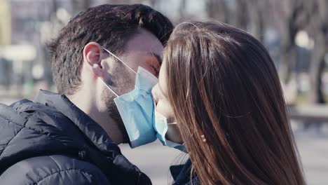 couple kissing with masks