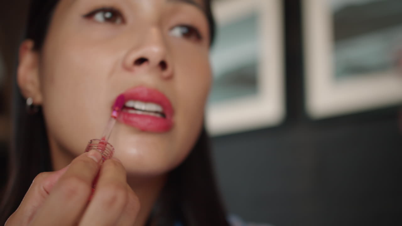 Asian Woman Covering Lips with Red Lipstick