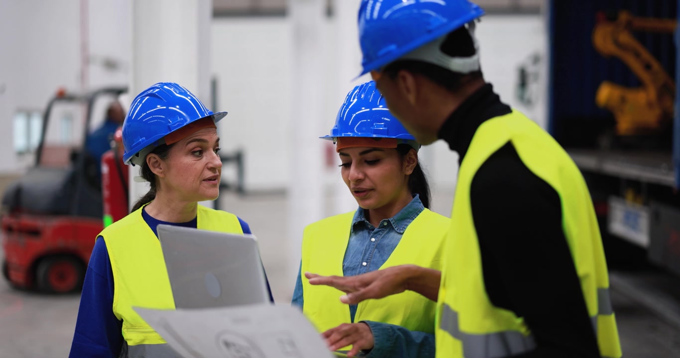 Industrial Workers Discussing Project Plans in Warehouse