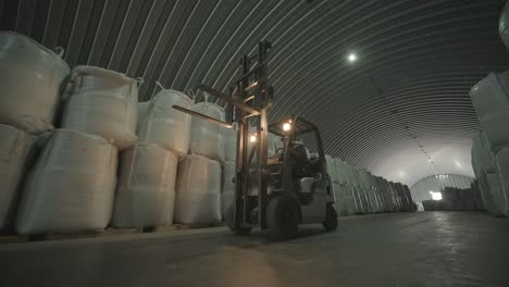 warehousing. forklift driver stacking big bag of raw material in warehouse. many bags of raw materials in the warehouse