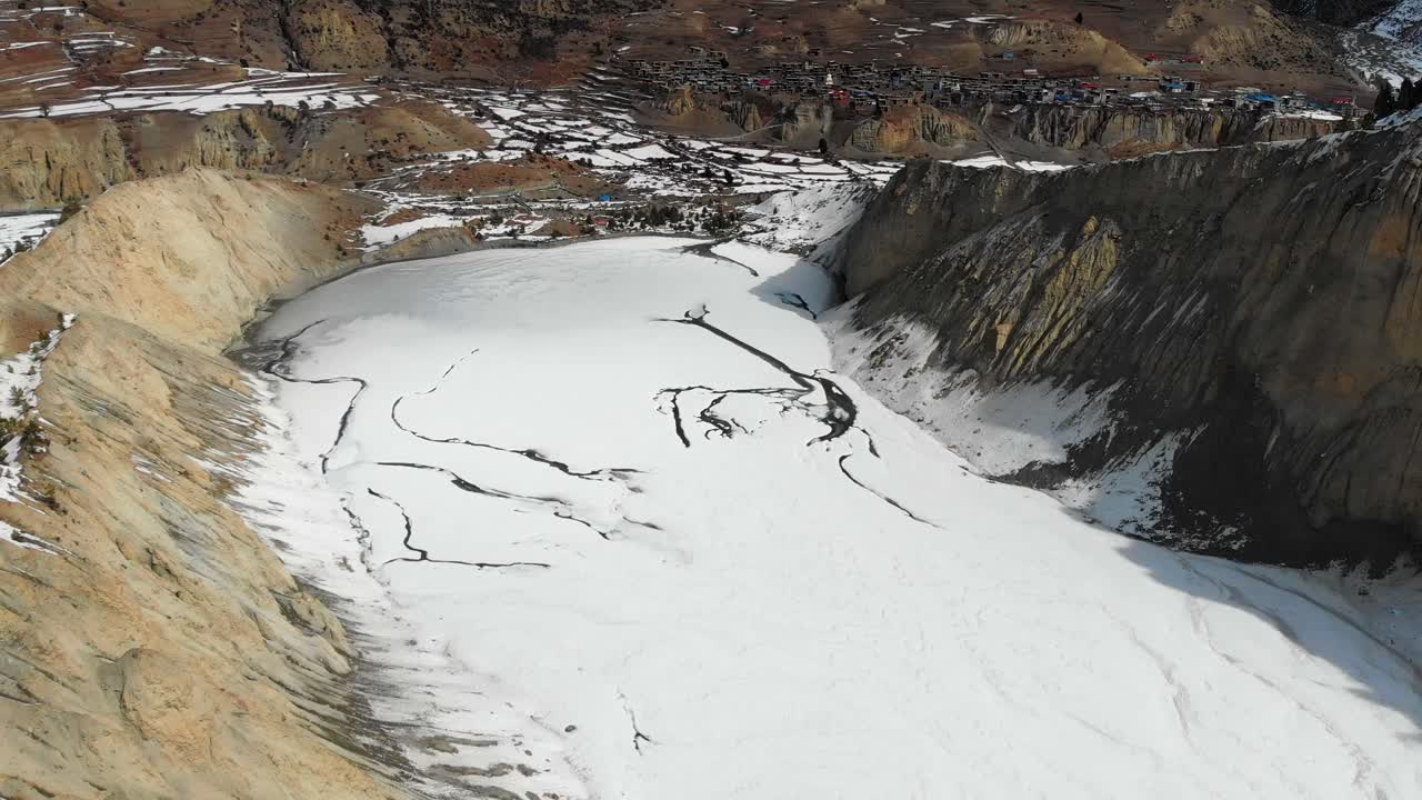 Drone view of frozen Gangapurna glacial moraine lake in winter in Manang Valley, Nepal.