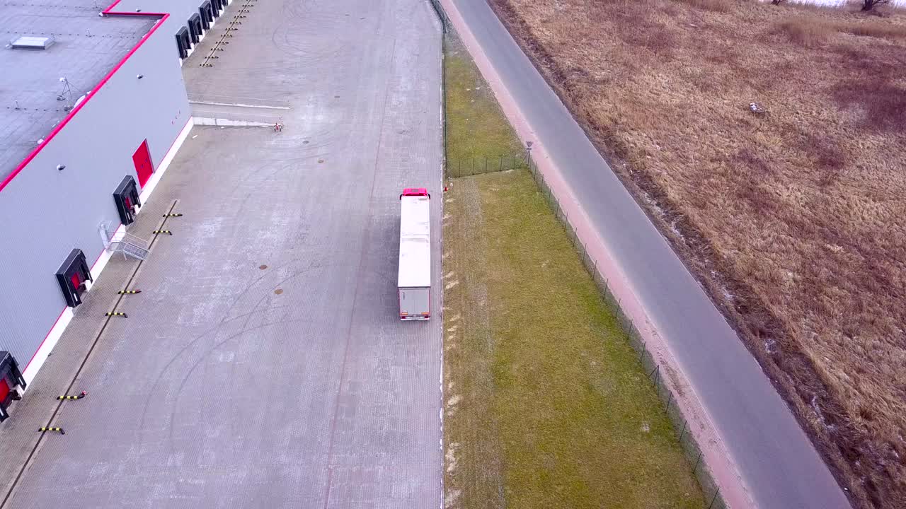 트럭이 물류 센터로 운전하고 있습니다.