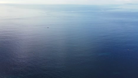 fishing boat anchored in heart of blue ocean