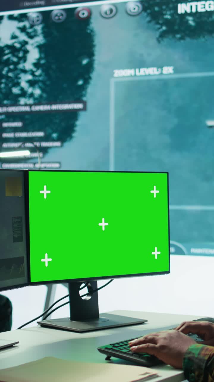 Vertikal video: Militærekspert håndterer satellit CCTV-data ved siden af mockup-skærm.