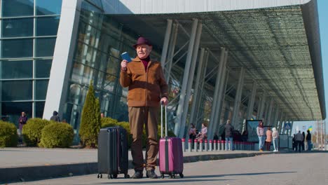 Portrait-of-senior-pensioner-tourist-grandfather-stay-near-airport-hall-waiting-for-plane,-travel