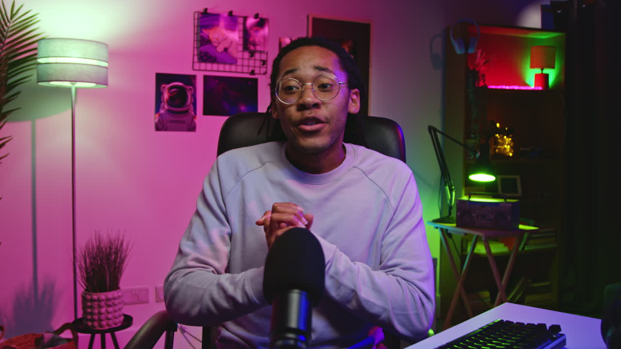 un hombre negro hablando en un micrófono en un escenario de estudio