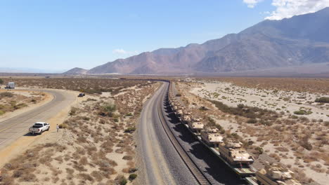 Tren-Del-Ejército-Que-Transporta-Vehículos-Militares-Y-Tanques-Por-Ferrocarril-A-Través-Del-Desierto-En-Los-Estados-Unidos