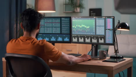 person working on multiple computer monitors for stock trading