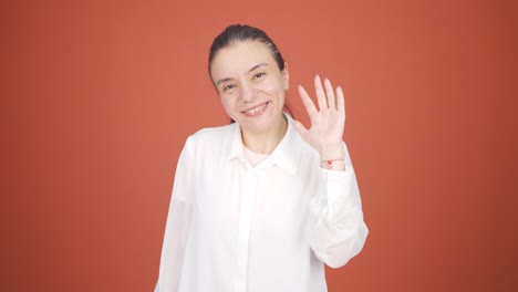 Happy-woman-waving-at-camera.