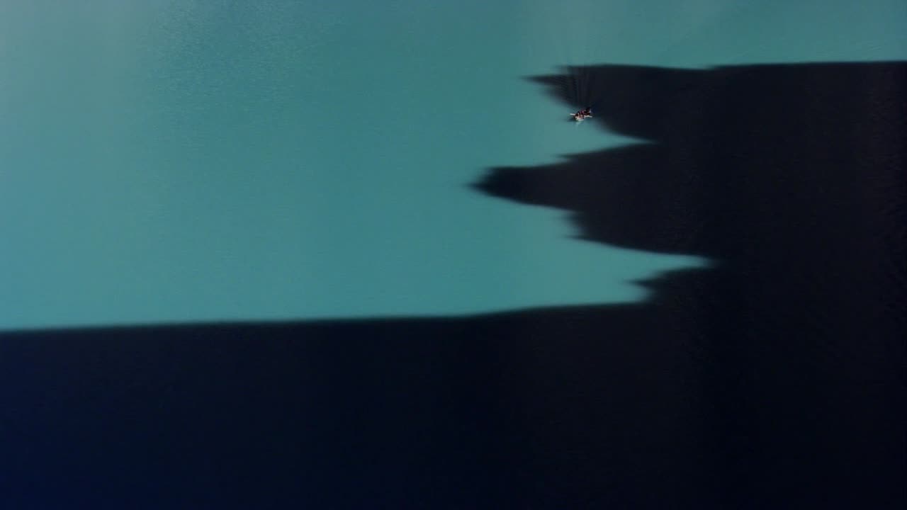 This close-up aerial view of Attabad Lake in northern Pakistan captures the lake’s vivid turquoise waters flowing alongside steep, rocky cliffs