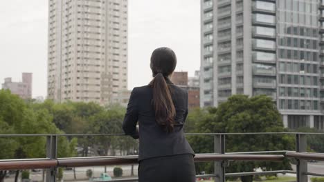 back view businesswoman stretching on terrace