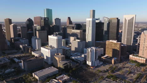 Drone-shot-around-the-sunlit-downtown-of-Houston,-golden-hour-in-Texas,-USA