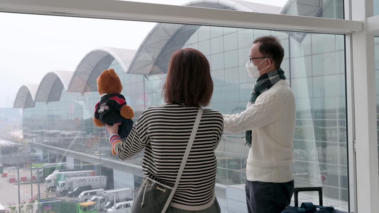 una pareja toma fotos de sus ositos de peluche vistos en el aeropuerto internacional chek lap kok de hong kong