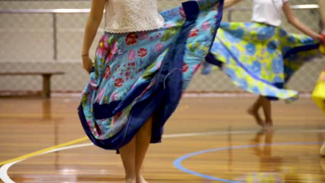 detail of women dancing in a presentation with colorful long round skirts