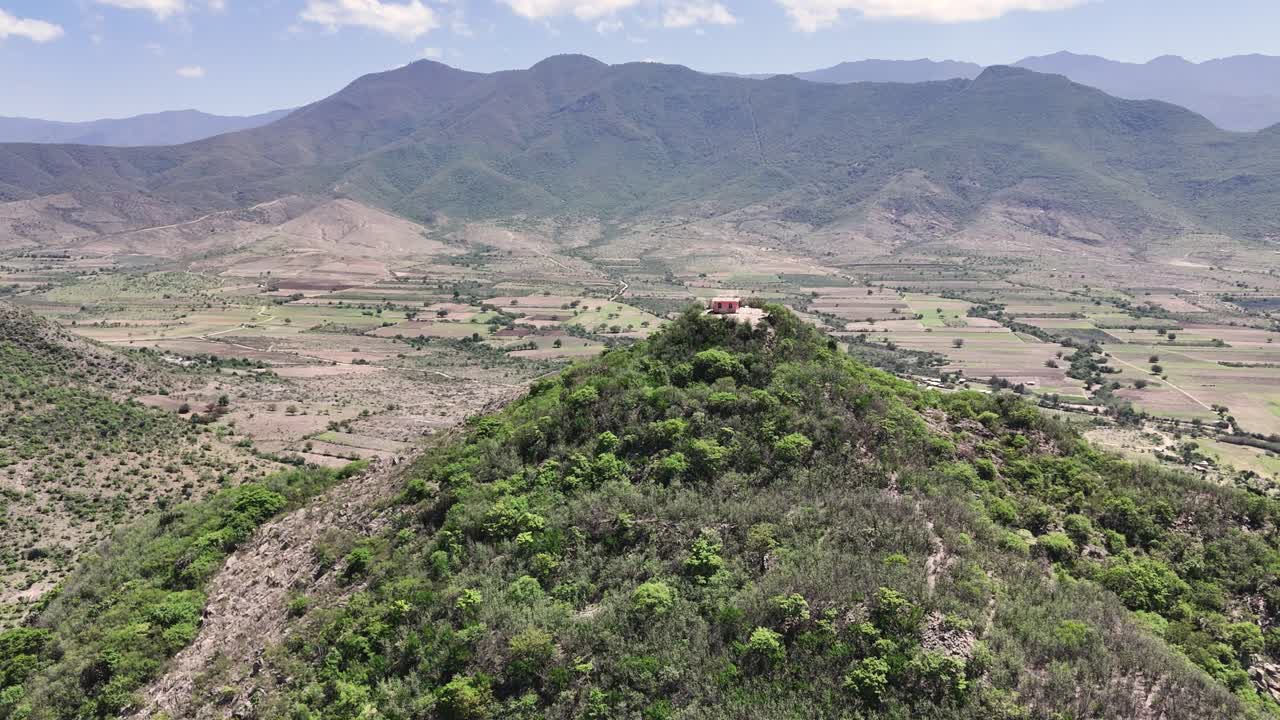 Mountain landscape with rural valley and building on hilltop