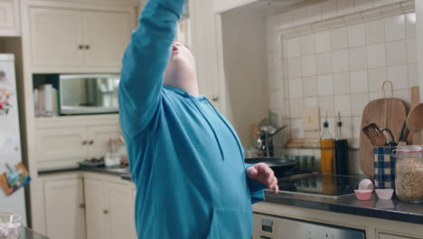 happy-teenage-boy-with-down-syndrome-dancing-in-kitchen-having-fun-celebrating-funny-dance-enjoying-weekend-at-home