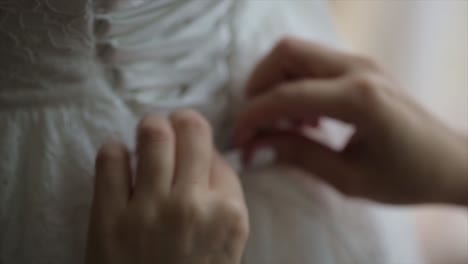 bride getting dressed in a white lace wedding dress